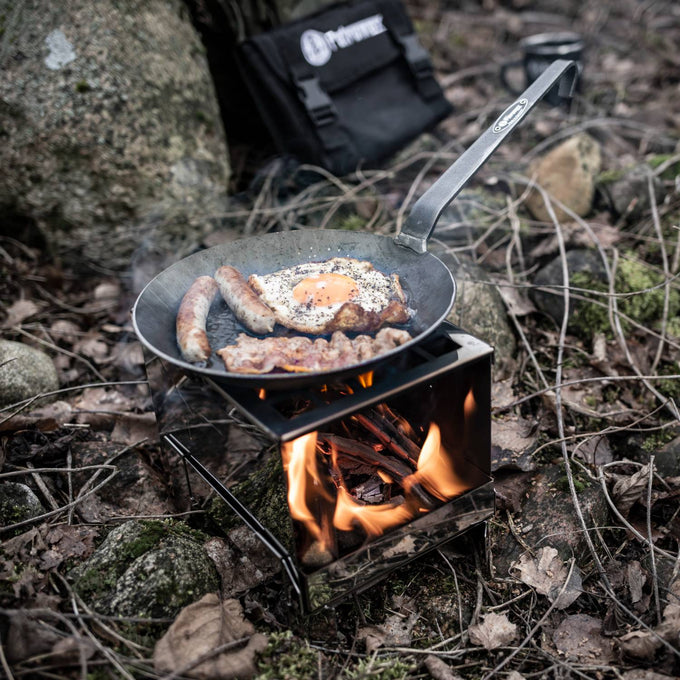 Handcrafted portable stainless steel camp stove with open fire burning wood, cooking breakfast with sausage, egg, and bacon outdoors in Farm, Garden & Tool, Camping, Emergency Supplies, Best Sellers, and Promo Eligible collections.