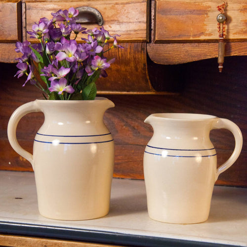 Pair of handcrafted cream stoneware pitchers with simple blue stripes, made in USA, ideal for Kitchen & Food, Dinnerware, Holiday Hosting, Storage and Serving, and Best Sellers collections.