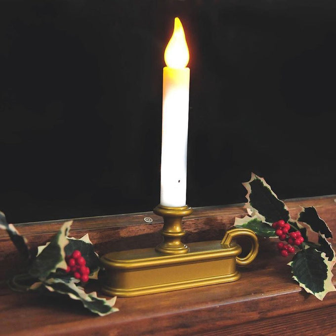 Battery-operated cordless window candle with a warm LED flame in a gold holder, accented by festive holly berries and leaves, perfect for Home & Decor and Holiday Decor collections.