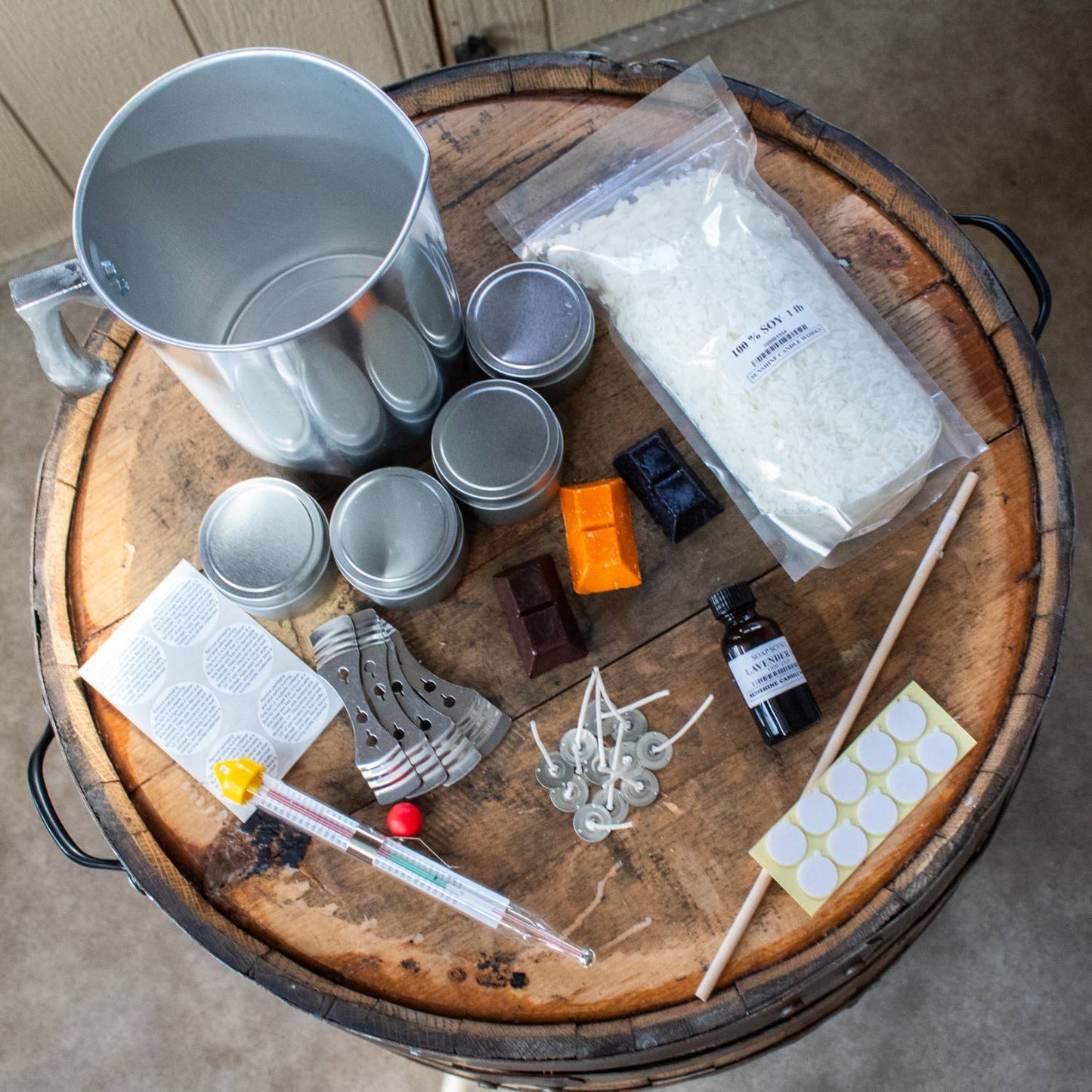 Handcrafted soy candle making kit featuring a metal melting pot, soy wax flakes, scented oil, wick sustainers, dye chips in red, yellow, and brown, thermometer, stirring stick, caution labels, and metal tins, suitable for Lamps & Lighting, Candles and Candlemaking, Candlemaking Supplies, Best Sellers, Promo Eligible collections.