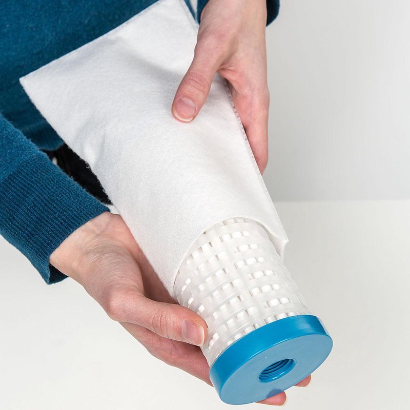 Person holding a handcrafted pleated water filter with a blue end cap, designed for reliable use in appliances from USA Made collections including Appliances and Water Heating and Treatment.