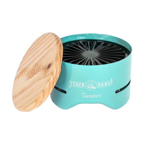 Compact turquoise tabletop charcoal grill with a removable wooden lid engraved with logo, designed for small outdoor grilling, featured in Farm, Garden & Tool and Camping collections.