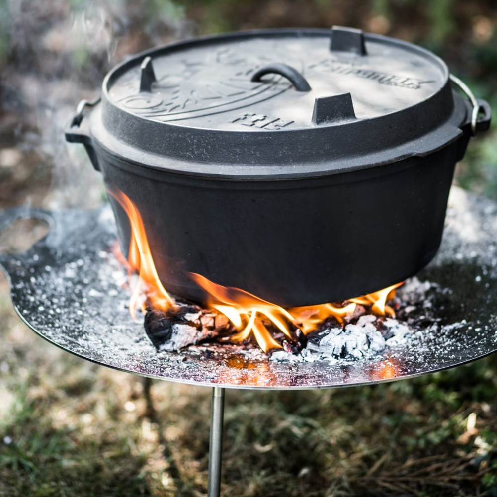 Robust cast iron Dutch oven with legs cooking over an open fire, ideal for outdoor and indoor use, featured in Kitchen & Food, Cookware, Cast Iron, Best Sellers, and Promo Eligible collections.