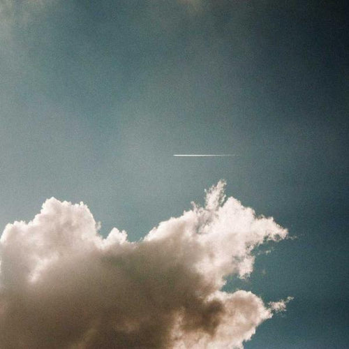 Soft, fluffy clouds drifting across a clear blue sky with a faint white streak from a distant airplane, evoking calm and natural beauty for Water Pumps and P3 Testing collections.