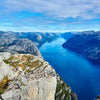 A panoramic view of a deep blue fjord surrounded by rugged cliffs and rocky terrain under a partly cloudy sky, conveying natural beauty and outdoor adventure, featured in Best Sellers and P3 Testing collections.