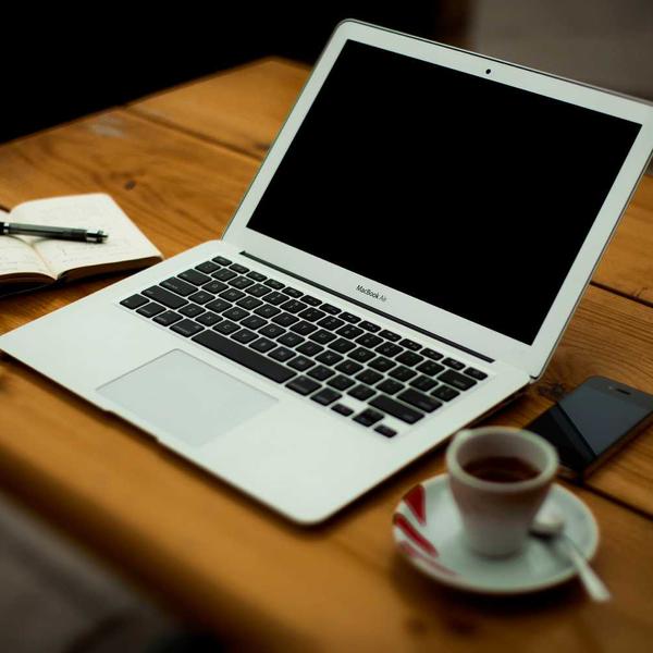 Open laptop with blank screen on wooden table beside notebook, pen, smartphone, and espresso cup, suggesting a cozy workspace for Best Sellers and P3 Testing collections.