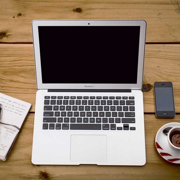 Open laptop with black screen on rustic wooden table surrounded by handwritten notebook, smartphone, and cup of coffee, evoking a calm, focused workspace for Best Sellers and P3 Testing collections.