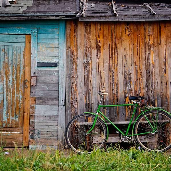 Vintage green bicycle leaning against a weathered wooden barn with peeling paint and rustic textures, evoking a nostalgic outdoor scene for Best Sellers and P3 Testing collections.
