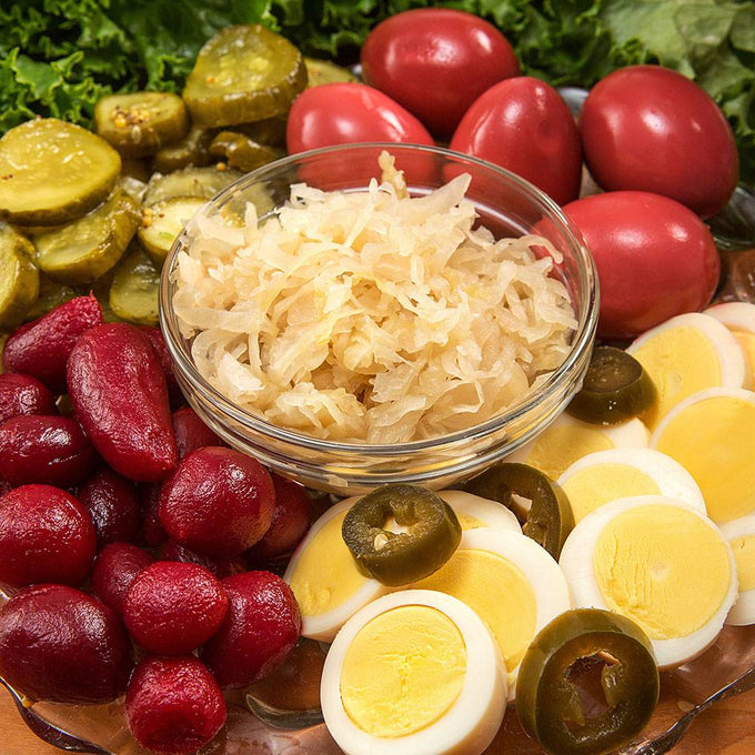 Glass bowl of shredded sauerkraut surrounded by sliced hard-boiled eggs with jalapeños, red potatoes, pickles, kidney beans, and fresh leafy greens, perfect for Kitchen & Food, Food, Pantry, USA Made, Best Sellers, and Promo Eligible collections.