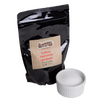 Resealable black pouch of handcrafted food-grade sodium hydroxide lye beads paired with a white ceramic ramekin of pure lye, ideal for soapmaking and health & wellness collections.