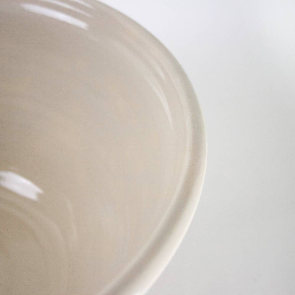 Close-up of a handcrafted stoneware mixing bowl in cream with heritage blue stripes, made in the USA, ideal for Kitchen & Food, Cookware, Baking Supplies, and Storage collections.
