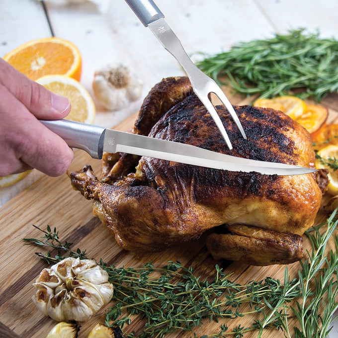 Handcrafted carving and boning knives with solid satin-finished recycled aluminum handles slicing a roasted chicken on a wooden board with fresh herbs, garlic, and citrus, featured in Farm, Garden & Tool, Kitchen & Food, Knives & Axes, Kitchen Knives, Food Prep, USA Made, and Best Sellers collections.