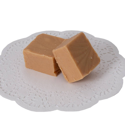Two handcrafted creamy caramel fudge pieces with smooth texture on a white decorative paper doily, part of Kitchen & Food, Snacks and Sweets, USA Made, and Best Sellers collections.