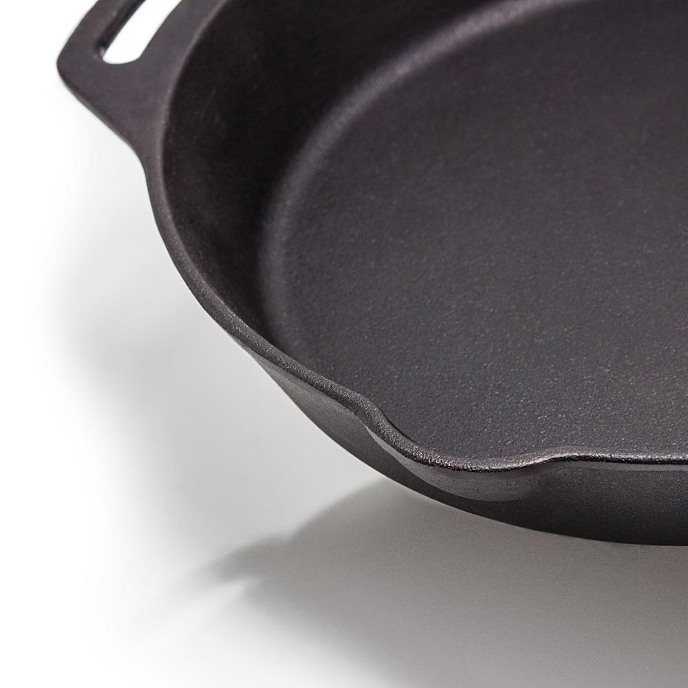 Close-up of a handcrafted cast iron skillet with two side handles and a pouring spout, ideal for cooking in farm, garden, camping, kitchen, and cookware collections.