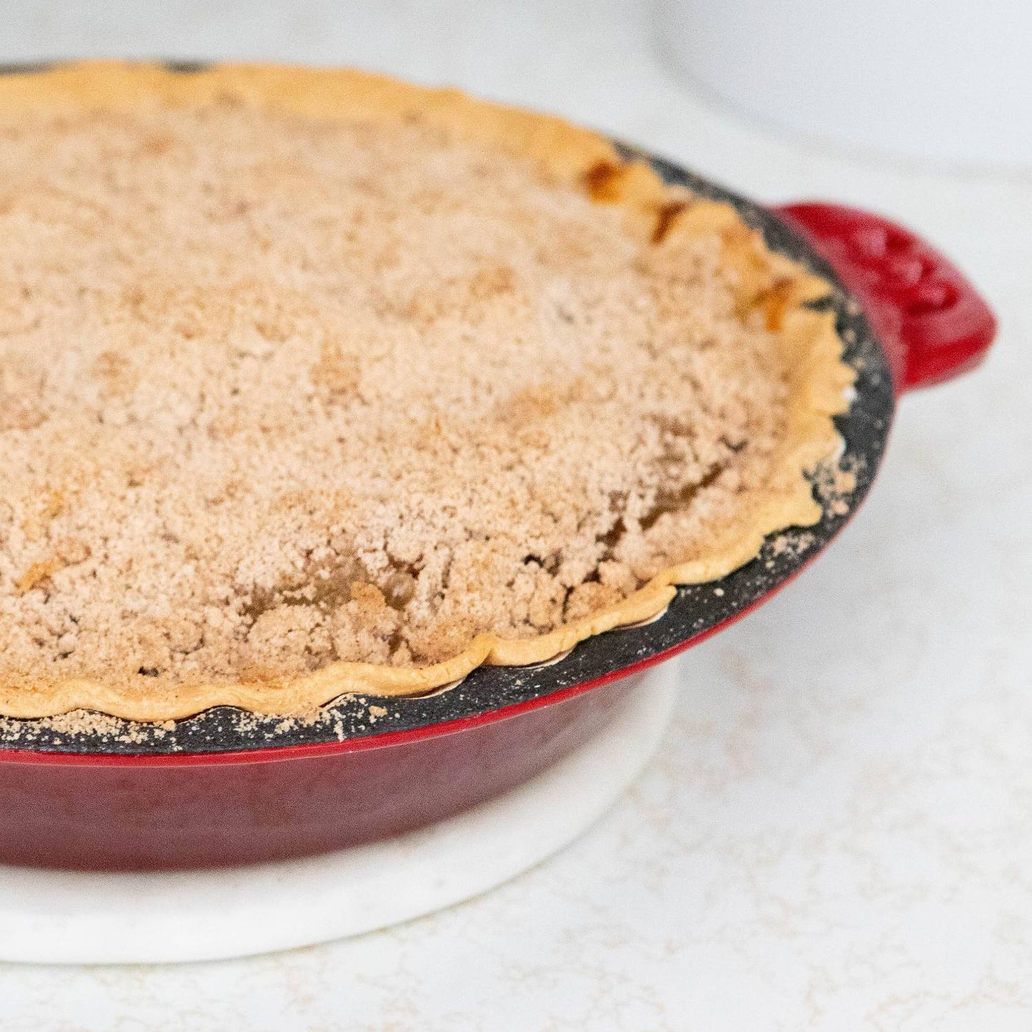 Handcrafted cast iron pie pan with decorative crimped edges and red finish holding a freshly baked crumb-topped pie, ideal for Kitchen & Food, Cast Iron, Cookware, Baking Supplies, Best Sellers, and Promo Eligible collections.