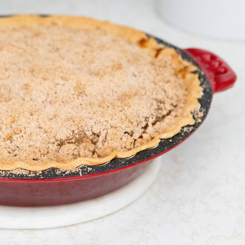 Handcrafted cast iron pie pan with decorative crimped edges and red finish holding a freshly baked crumb-topped pie, ideal for Kitchen & Food, Cast Iron, Cookware, Baking Supplies, Best Sellers, and Promo Eligible collections.
