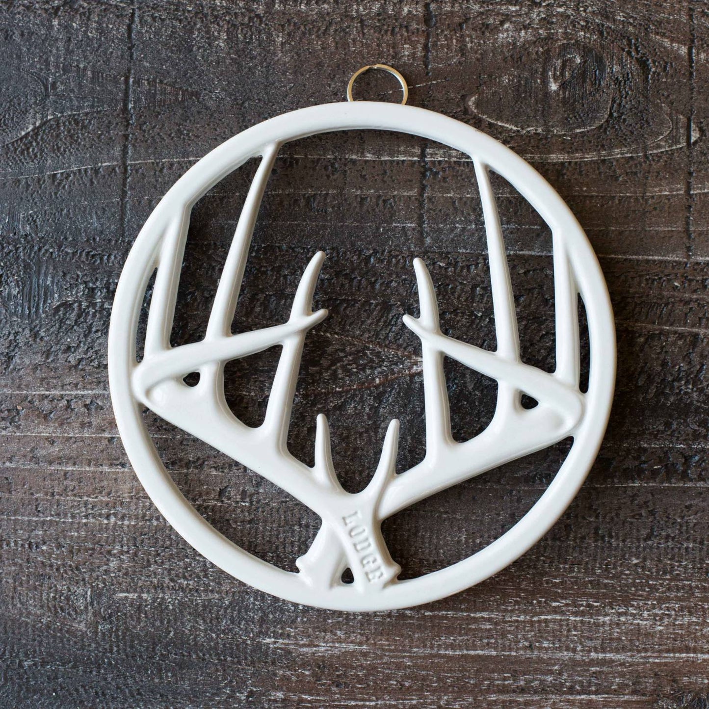 Round white enamel trivet with antler motif, featuring durable chipping-resistant finish, built-in hanger, and rubber feet, perfect for Kitchen & Food, Dinnerware, Storage and Serving, Best Sellers, and Promo Eligible collections.