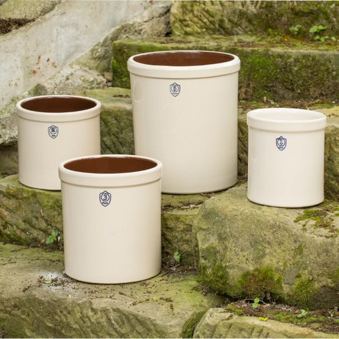 Group of handcrafted stoneware crocks in varying sizes with smooth off-white exterior and brown glazed interior, made in USA for Kitchen & Food, Food Preservation, and Fermenting collections.
