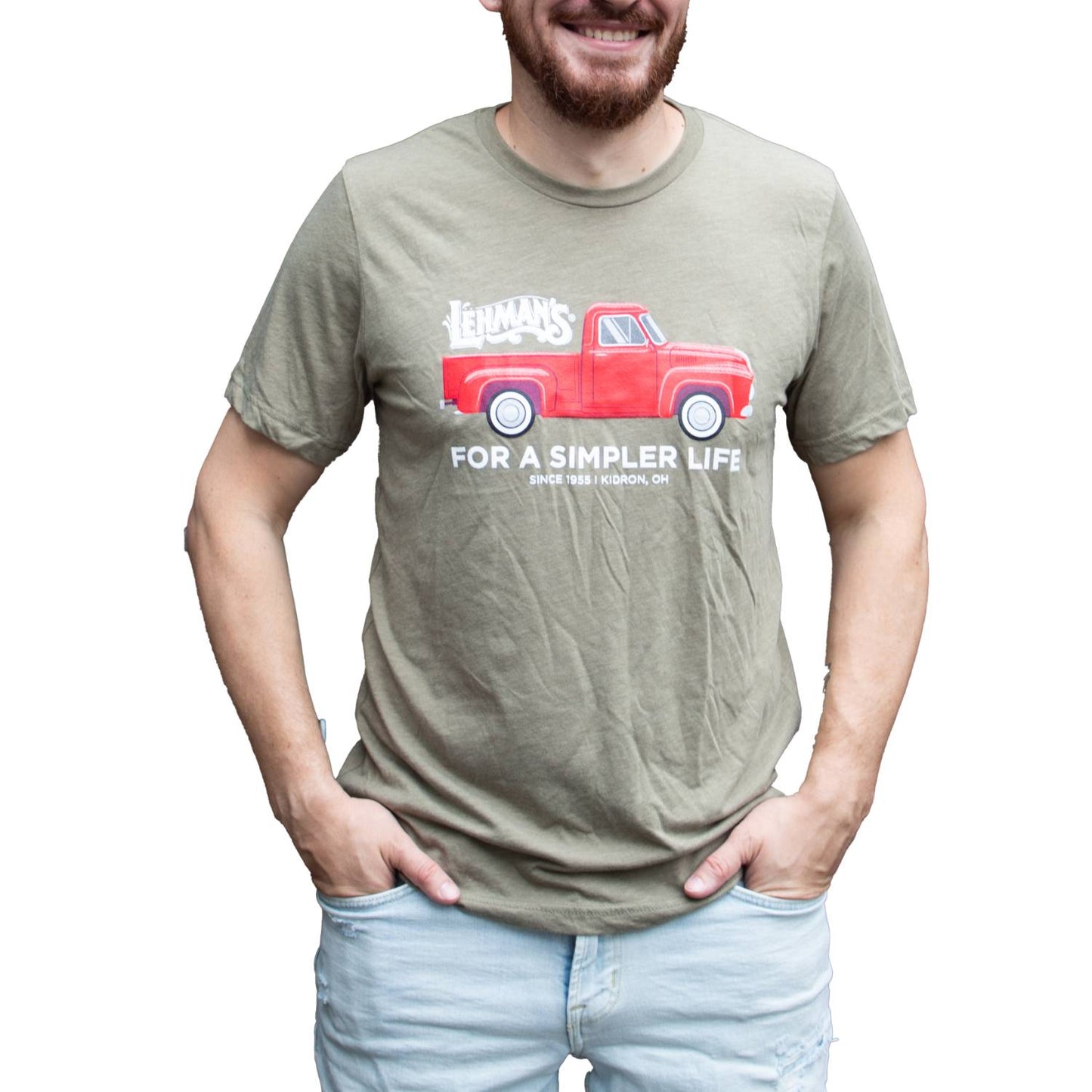 Adult wearing an olive handmade soft cotton t-shirt with a bright red vintage truck graphic, Lehman's logo, and "For a Simpler Life" text, perfect for Health & Wellness, Clothing and Accessories, Best Sellers, and Promo Eligible collections.