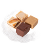 Four handcrafted creamy fudge squares in varied flavors including chocolate, praline, and caramel swirled, arranged on a white lace paper doily, ideal for Kitchen & Food and Snacks and Sweets collections.
