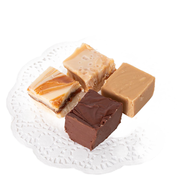 Four handcrafted creamy fudge squares in varied flavors including chocolate, praline, and caramel swirled, arranged on a white lace paper doily, ideal for Kitchen & Food and Snacks and Sweets collections.