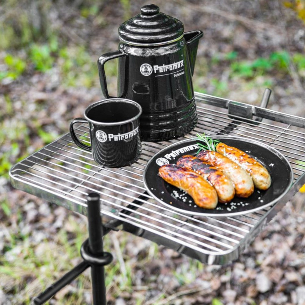 Black enamel camping plate with Petromax logo holding grilled sausages garnished with herbs, alongside a matching mug and coffee pot, ideal for Farm, Garden & Tool, Kitchen & Food, Camping, Dinnerware, and Best Sellers collections.