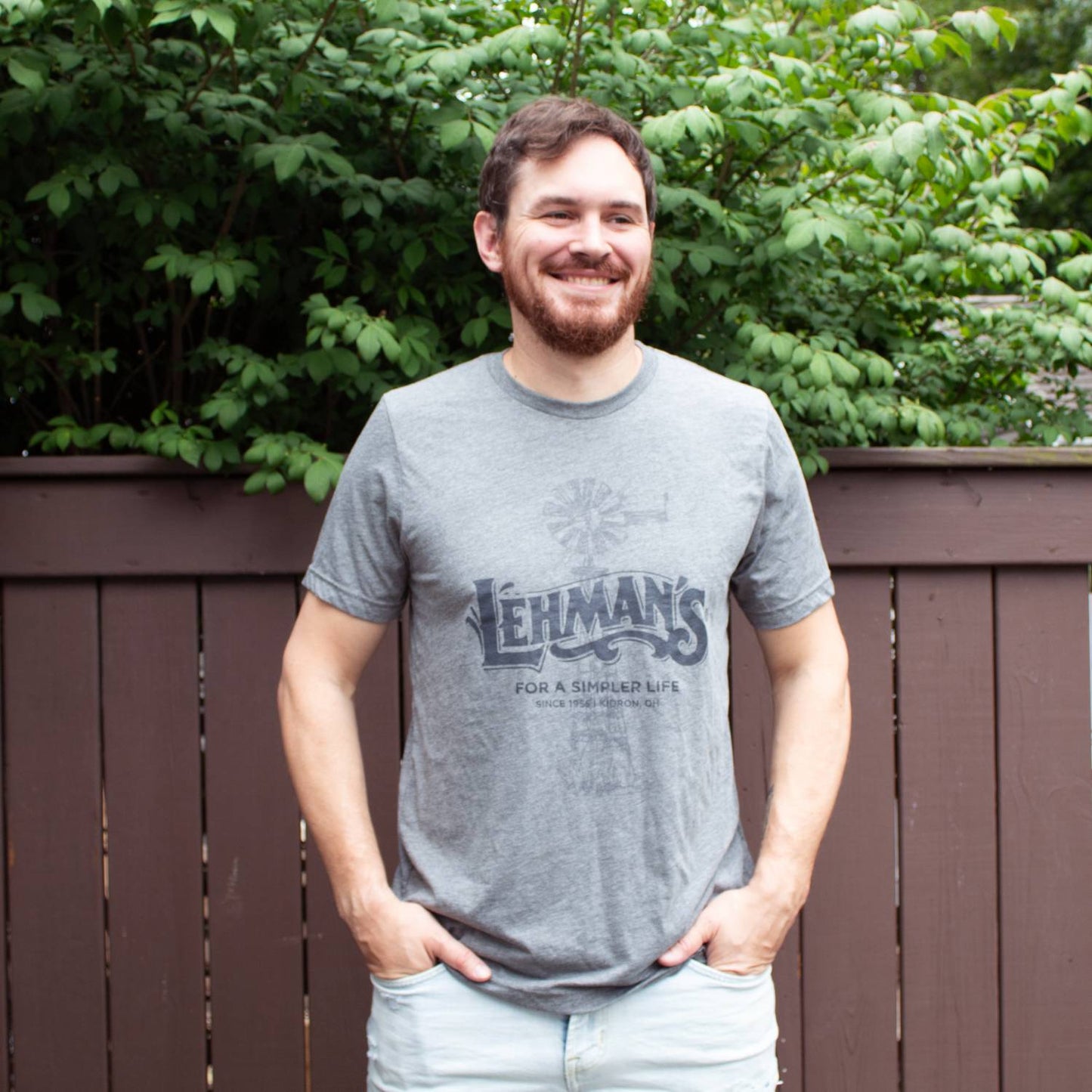 Man wearing a soft, lightweight gray t-shirt featuring a vintage-style windmill graphic and "Lehman's For a Simpler Life" print, ideal for Health & Wellness, Clothing and Accessories, and Best Sellers collections