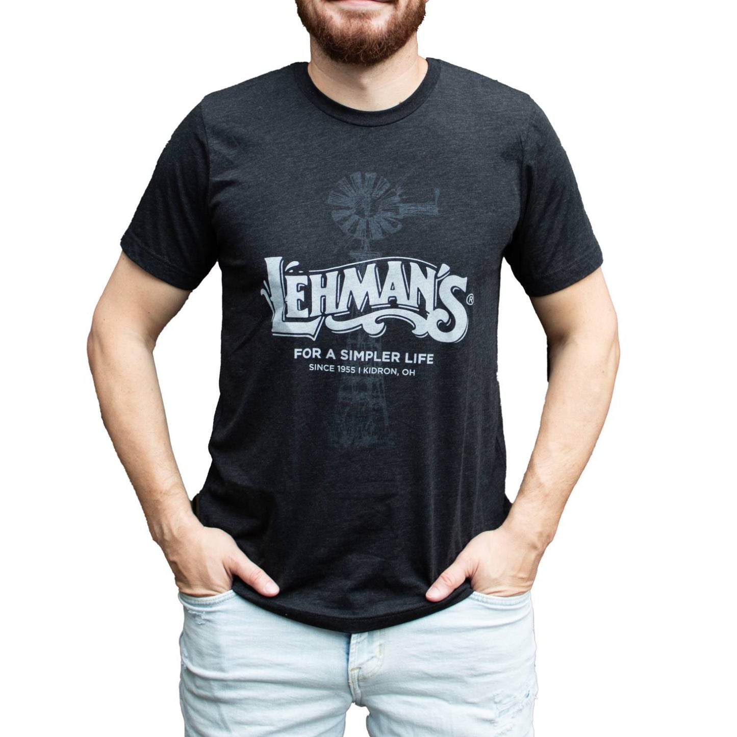 Man wearing a soft, lightweight dark gray t-shirt with a subtle windmill graphic and bold Lehman's "For a Simpler Life" print, designed for Health & Wellness, Clothing and Accessories, Best Sellers, and Promo Eligible collections.