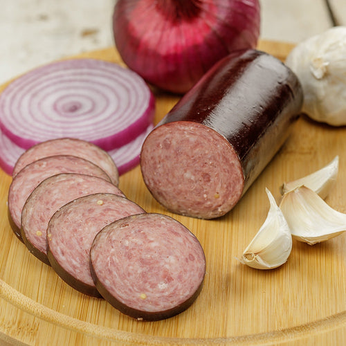 Handcrafted smoked summer sausage featuring a blend of pork and beef, sliced on a wooden board with red onion and garlic, perfect for Kitchen & Food, Snacks and Sweets, Pantry, Meats, and USA Made collections.