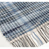 Close-up of a handcrafted woven denim rug in varying shades of blue with a textured pattern and fringed edge, featured in Home & Decor, Home Textiles, USA Made, and Best Sellers collections.
