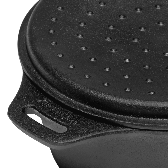 Close-up of a durable cast iron saucepan lid with raised self-basting bumps and sturdy handle, designed for precise pouring and outdoor cooking in farm, garden, camping, and cookware collections.