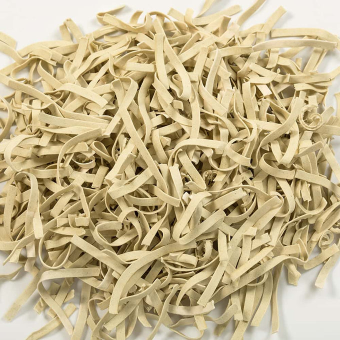 Pile of uncooked gluten-free homestyle egg noodles with a natural beige color, handcrafted and made in the USA, featured in Kitchen & Food, Pantry, Gluten Free, USA Made, and Best Sellers collections.