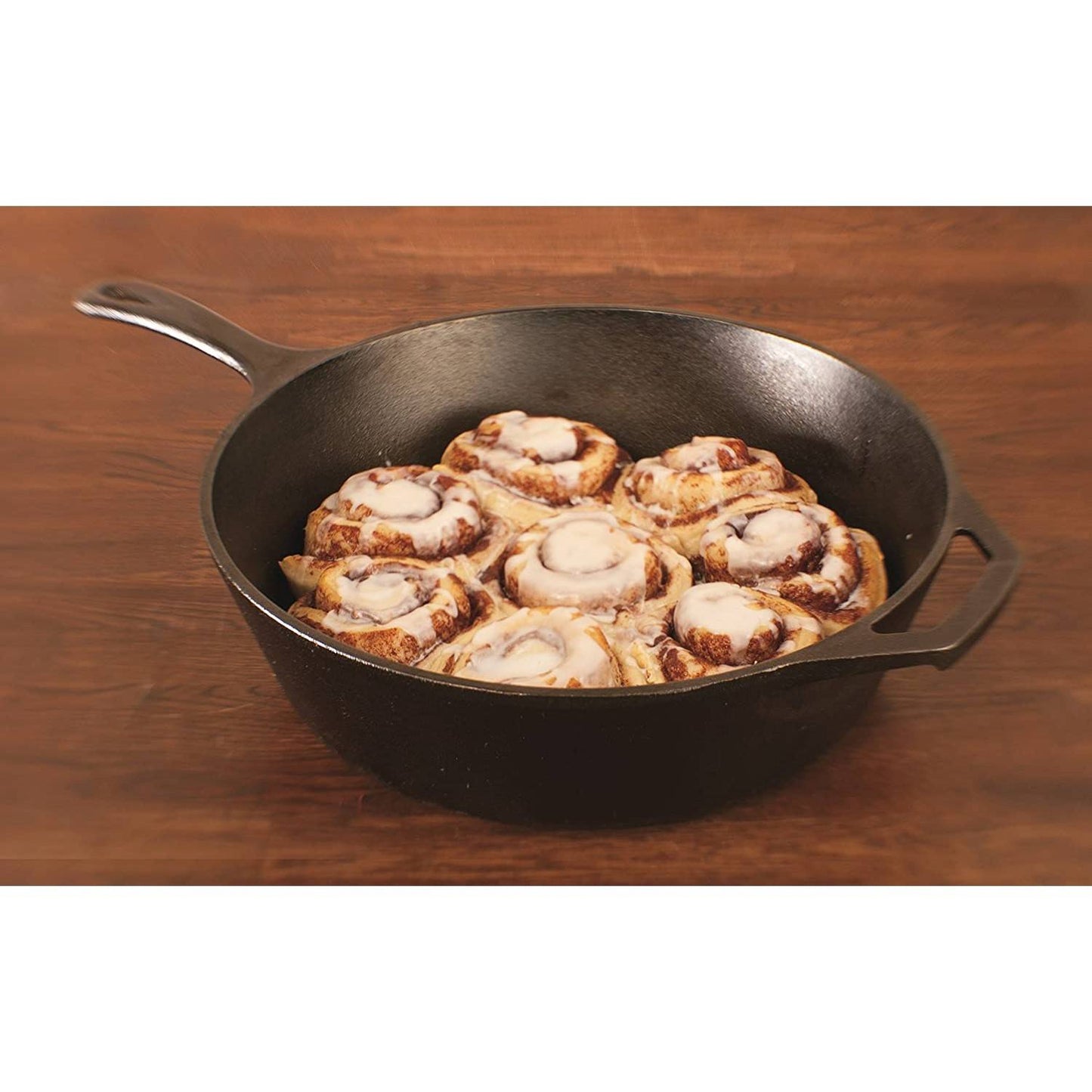 Black cast iron deep skillet filled with freshly baked cinnamon rolls with icing, featuring an assist handle and long grip, ideal for Farm, Garden & Tool, Kitchen & Food, Camping, and Cookware collections.
