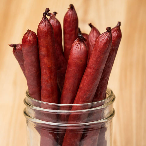 Handcrafted hickory-flavored beef sticks made in USA, displayed standing upright in a clear glass jar, ideal for Kitchen & Food, Snacks and Sweets, Meats, Holiday Hosting, Best Sellers, and Promo Eligible collections.