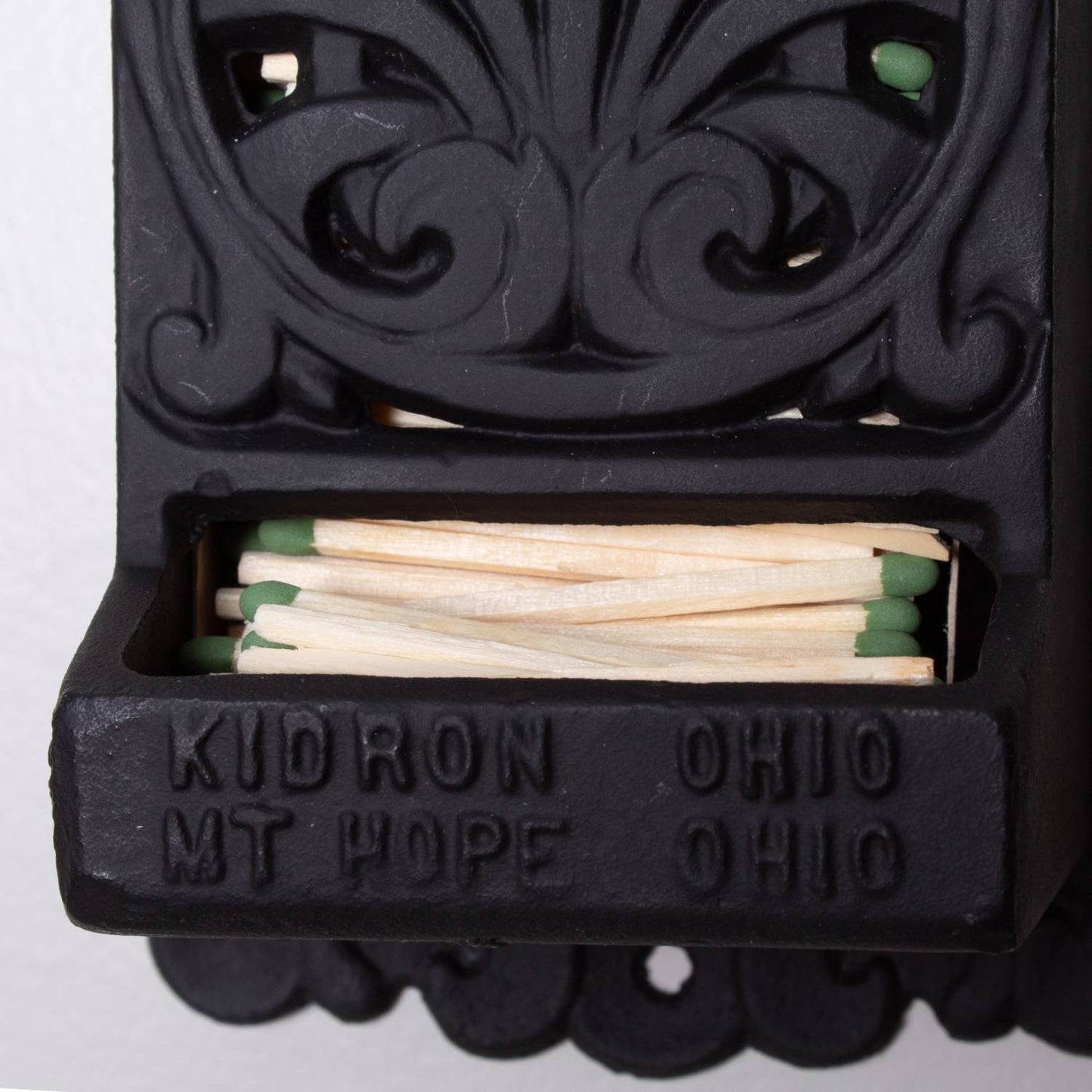 Handcrafted black cast iron wall-mounted matchbox holder with embossed "Kudron Ohio Mt Hope Ohio," featuring vintage decorative scrollwork, Amish made in USA, perfect for Home & Decor and Household Helpers collections.