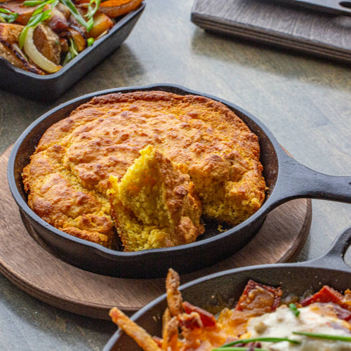 Pre-seasoned cast iron skillet with golden cornbread fresh from the oven, highlighting superior heat retention and durability in Kitchen & Food, Cookware, Cast Iron, Best Sellers, and Promo Eligible collections.