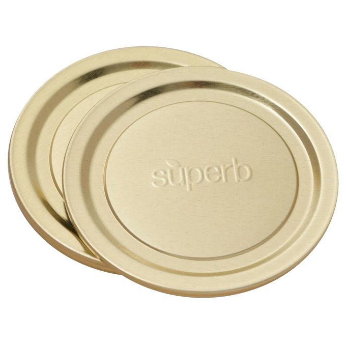 Two wide-mouth metal canning jar lids with embossed "superb" logo, designed for secure sealing, featured in food preservation and kitchen collections, made in USA.