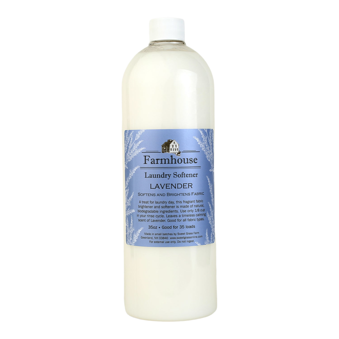 Tall translucent bottle of lavender-scented fabric softener with a blue label featuring a farmhouse illustration, part of USA made laundry supplies and best sellers collections.