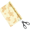 Roll of cream-colored beeswax food wrap printed with honeycomb patterns, partially unrolled next to black-handled scissors, handmade and USA made, ideal for Kitchen & Food and Storage collections.