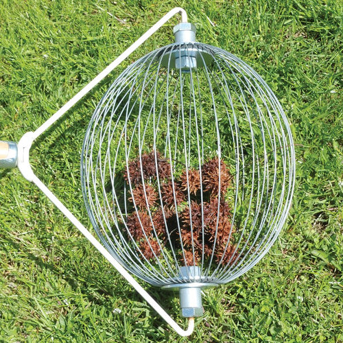 Round metal nut gatherer with wooden handle filled with sweet gum seed pods on green grass, designed to ease yard cleanup without bending; featured in Farm, Garden & Tool, Lawncare, Best Sellers, and Promo Eligible collections.