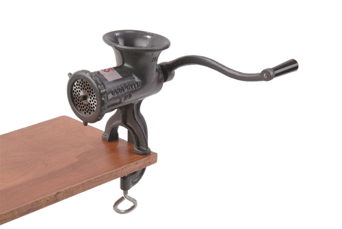 Heavy-duty clamp-down metal meat grinder with long crank handle attached to wooden surface, featuring durable construction and suitable for Kitchen & Food, Specialty Equipment, Butchering Supplies, USA Made, Best Sellers, and Promo Eligible collections.