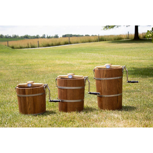 Three handcrafted Amish made wooden ice cream freezers with sturdy metal bands and smooth hand cranks, displayed outdoors on grass for Kitchen & Food and Specialty Equipment collections.
