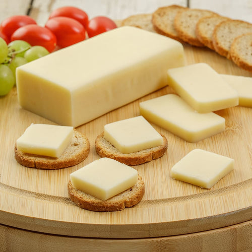 Handcrafted shelf-stable cheese food block with slices served on round crackers, accompanied by grape tomatoes and green grapes, ideal for Kitchen & Food, Snacks and Sweets, Pantry, USA Made, Best Sellers, and Promo Eligible collections.