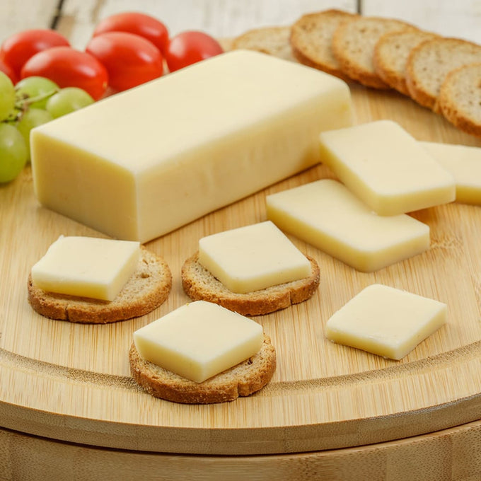 Handcrafted shelf-stable cheese food block with slices served on round crackers, accompanied by grape tomatoes and green grapes, ideal for Kitchen & Food, Snacks and Sweets, Pantry, USA Made, Best Sellers, and Promo Eligible collections.