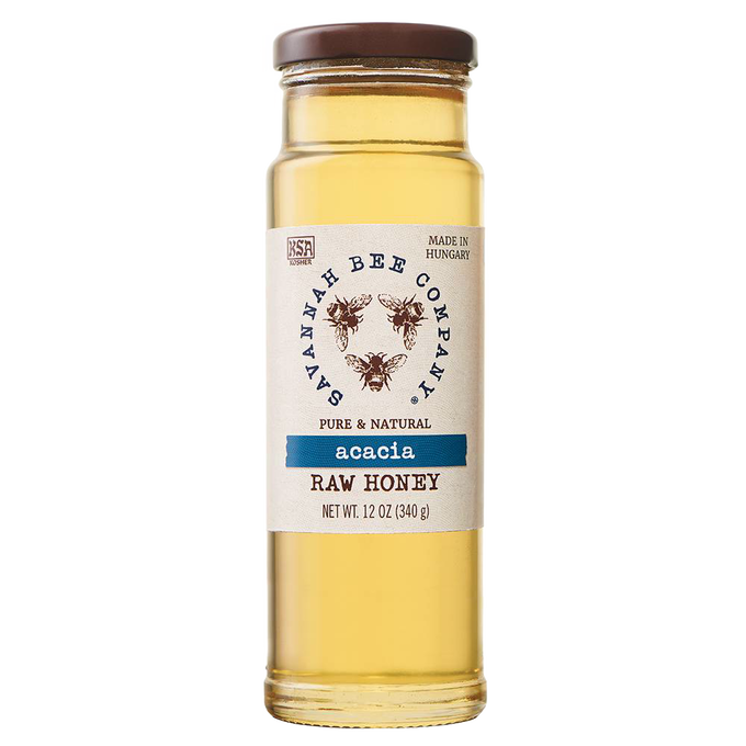Clear glass jar of pale golden acacia raw honey with a brown lid and natural label featuring bees, ideal for Pantry and Kitchen & Food collections in Best Sellers and Sale.
