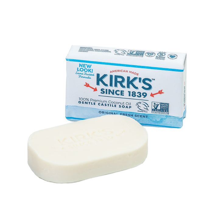 Bar of creamy white gentle castile soap with embossed branding, displayed next to its American made packaging featuring premium coconut oil and natural ingredients, ideal for Health & Wellness and Grooming collections.