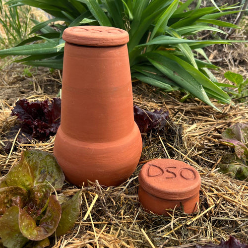 Handcrafted unglazed terra cotta watering pot with lid, buried in garden soil for slow water release, ideal for small garden beds and containers, featured in Farm, Garden & Tool and Garden Accessories collections.
