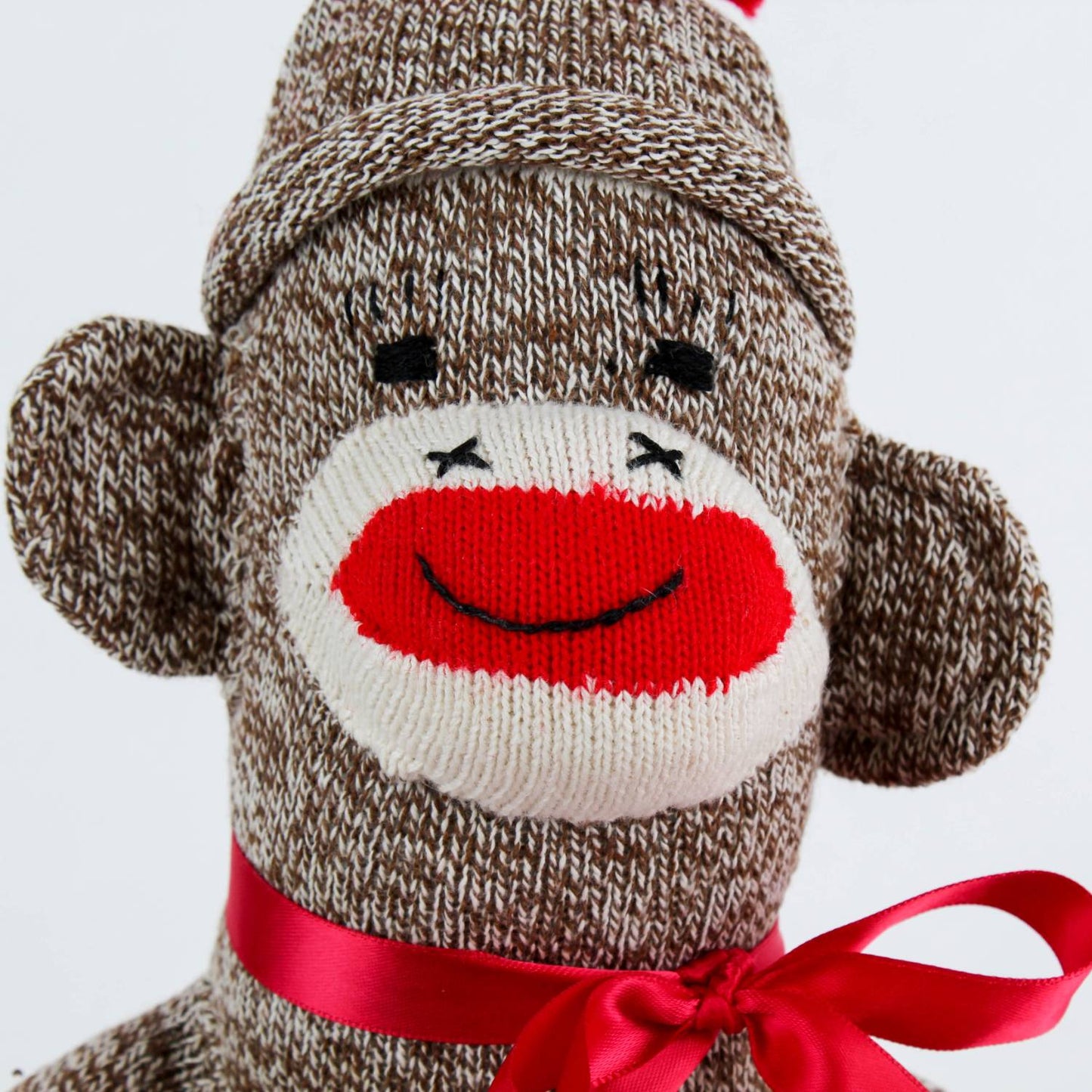 Handcrafted sock monkey made in USA from brown and cream knit socks, featuring a red knitted mouth, black stitched eyes, and a red ribbon bow, part of Toys, Books & Games and Children's Toys collections.