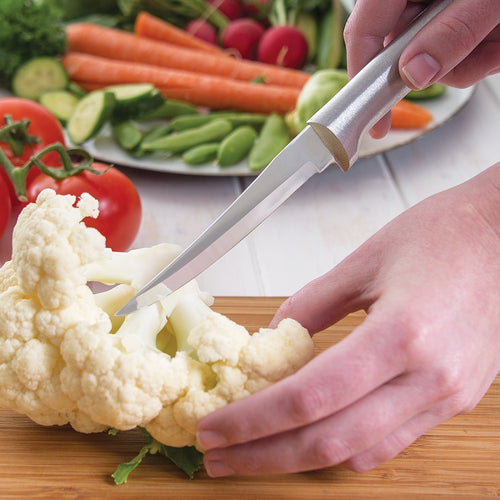 Handcrafted paring knife with a solid aluminum handle slicing cauliflower on a wooden cutting board, surrounded by fresh vegetables, ideal for kitchen and food prep collections.