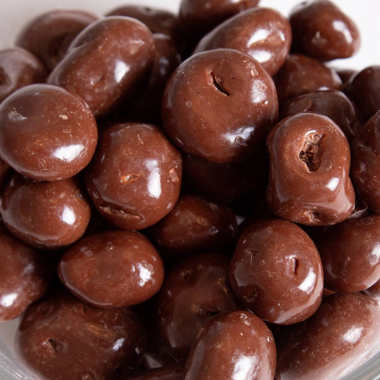 Close-up of handcrafted milk chocolate covered raisins, glossy and plump, a delicious snack made in USA included in Kitchen & Food, Snacks and Sweets, Candy, USA Made, Best Sellers, Promo Eligible collections.